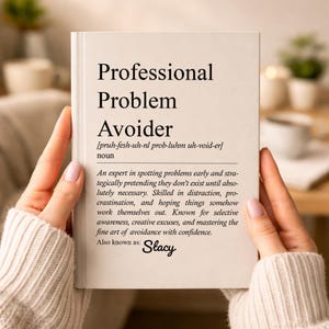May include: A book titled "Professional Problem Avoider" with a definition and the name "Stacy" below. The book is held by a person with a blurred background.