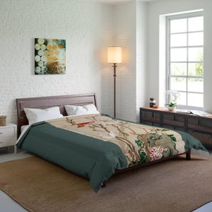 Könnte beinhalten: Ein tealfarbener und beiger Bettbezug mit einem Blumendruck, der einen Vogel und Magnolienblüten zeigt. Der Bettbezug liegt auf einem Bett mit weißen Kissen.