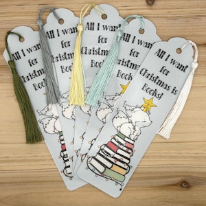 May include: A collection of light blue bookmarks with colorful tassels. Each bookmark features a Christmas-themed illustration of a fox on a stack of books, with the text "All I want for Christmas is Books!"