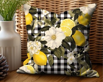 May include: Black and white checkered throw pillow with a floral and lemon design. The pillow features white flowers, green leaves, and yellow lemons.