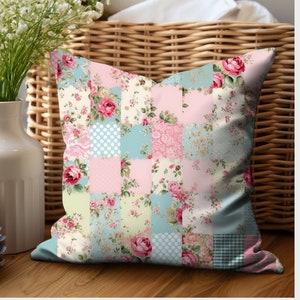 May include: A decorative pillow with a patchwork design featuring floral patterns in shades of pink, blue, and green. The pillow has a square shape and is made of soft fabric.