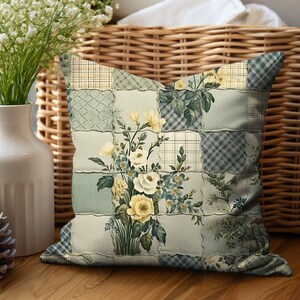 May include: A decorative throw pillow with a patchwork design featuring a floral motif in shades of green, white, and yellow. The pillow has a square shape and a soft, textured fabric.