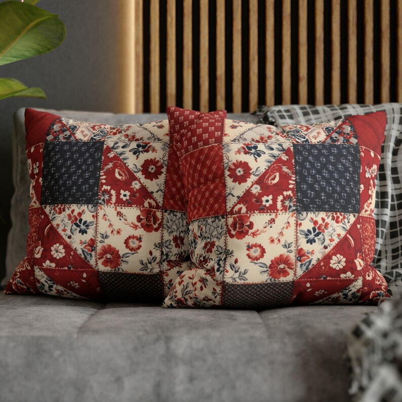 May include: Two red, white, and blue patchwork throw pillows with floral patterns. The pillows are on a gray couch.