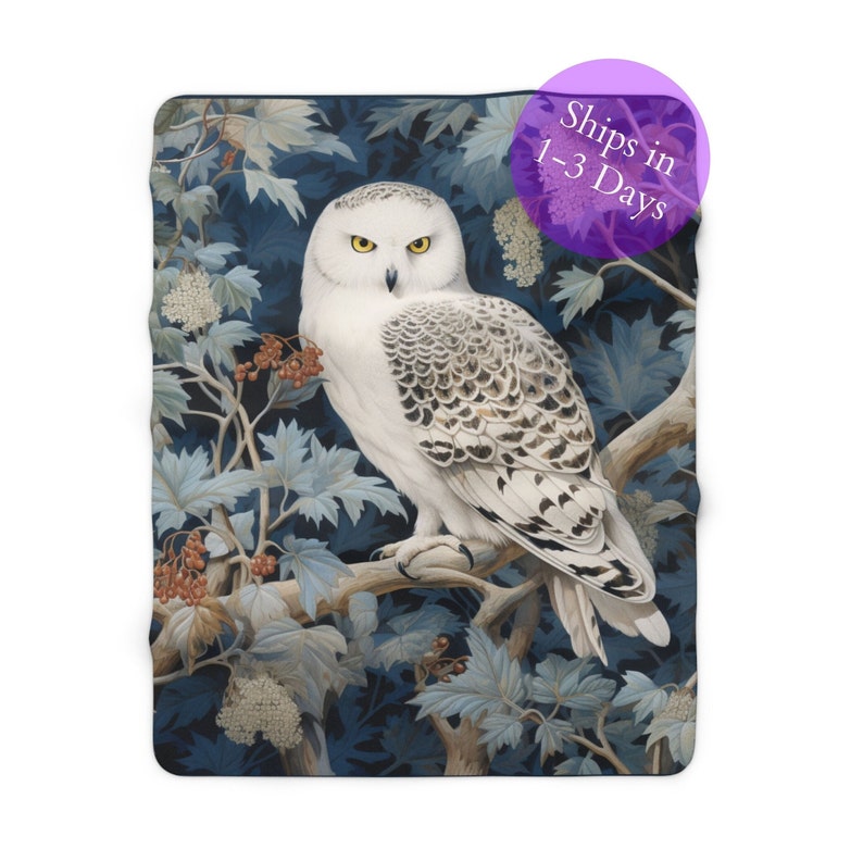 May include: A white snowy owl with black markings perched on a branch with blue and green leaves. The owl has yellow eyes and is looking directly at the viewer.