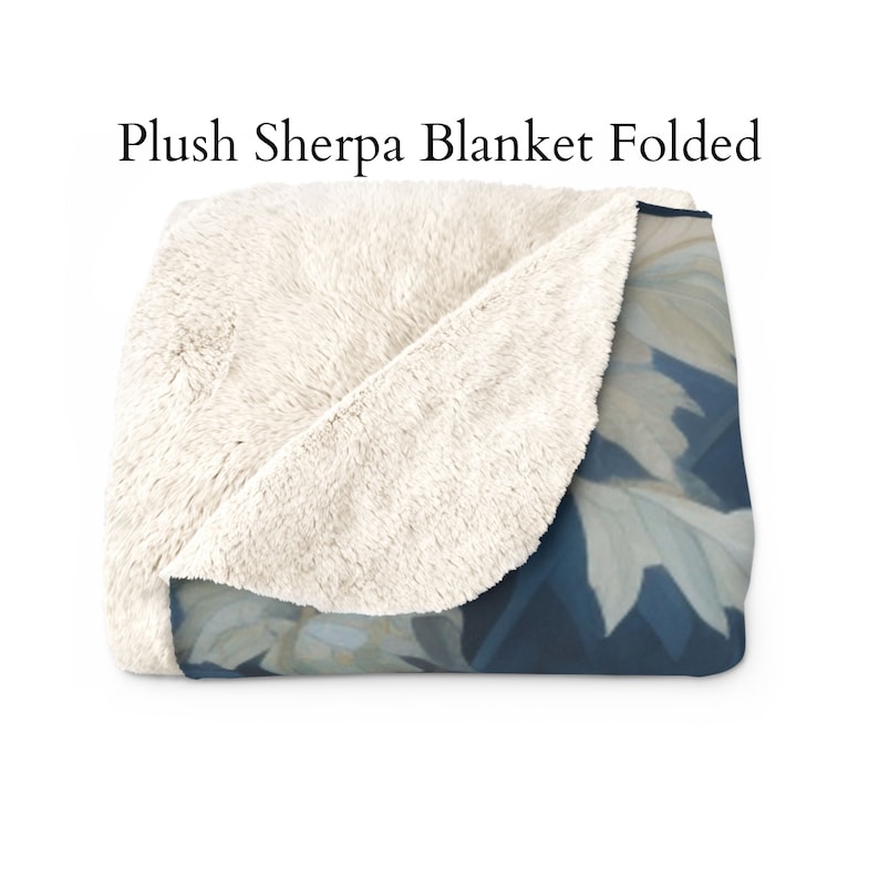 May include: A folded plush sherpa blanket with a white sherpa side and a blue and white floral print side.