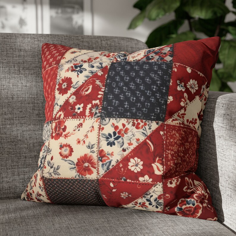 May include: A red, white, and blue patchwork pillow with a floral pattern. The pillow is made of different fabrics and has a quilted design.