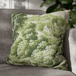 May include: Green and white throw pillow with a scenic countryside print featuring a small house, trees, and a winding path.