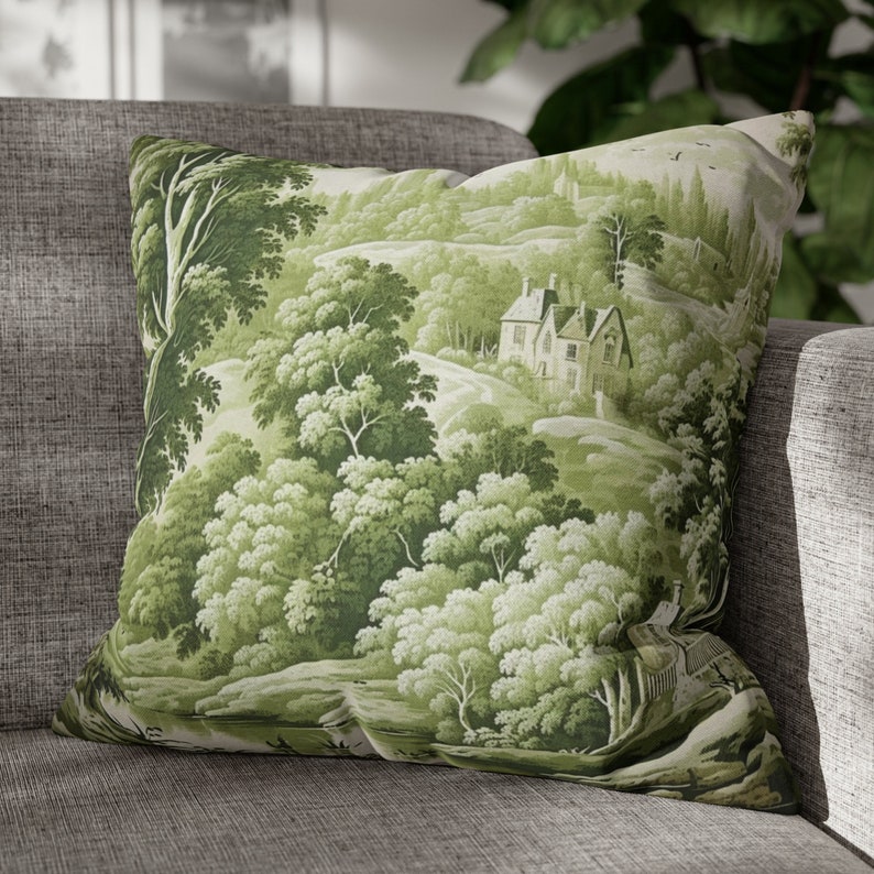 May include: Green and white throw pillow with a scenic countryside print featuring a small house, trees, and a winding path.