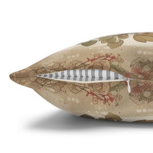 May include: A decorative throw pillow with a vintage floral pattern in shades of brown, red, and green. The pillow has a zipper closure and a white and gray striped lining.