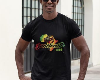 May include: Black t-shirt featuring a graphic of a raised fist, the African continent, and the words "Juneteenth 1865" in red, yellow, and green. The design is centered on the front of the shirt.
