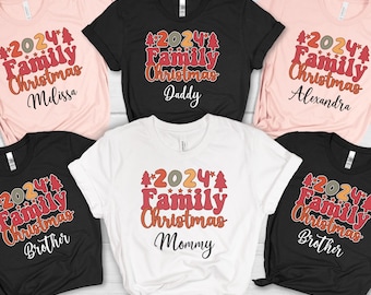 May include: A collection of t-shirts in black, white, and pink, each featuring the text "2024 Family Christmas" along with names. The design is retro, with the year and text in a festive, colourful font.