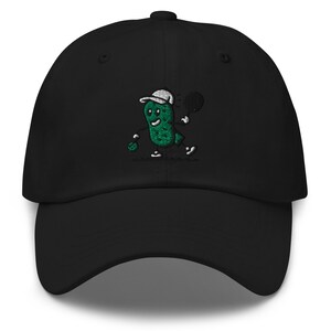 May include: Black baseball cap with an embroidered green pickle character playing tennis. The pickle is wearing a white hat and holding a tennis racket.