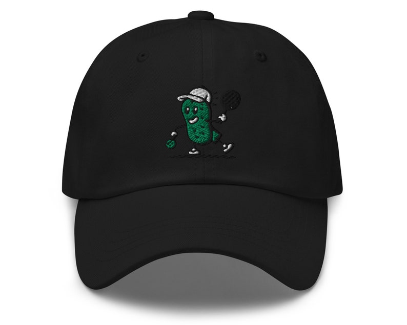 May include: Black baseball cap with an embroidered green pickle character playing tennis. The pickle is wearing a white hat and holding a tennis racket.
