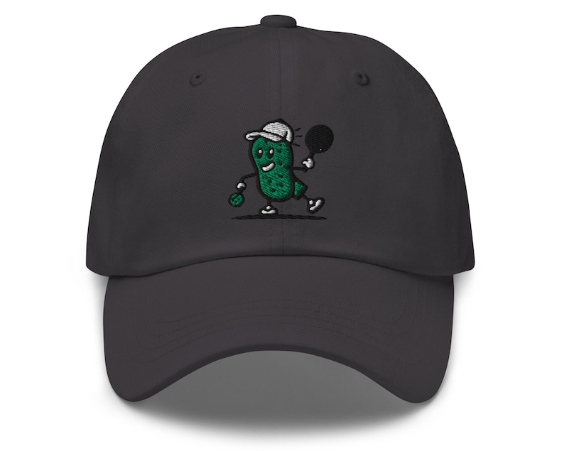 May include: A dark gray baseball cap with an embroidered green pickle character playing tennis. The pickle is wearing a white hat and holding a tennis racket.