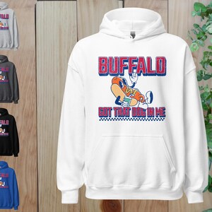May include: White hooded sweatshirt with a graphic of a cartoon hot dog with the text "BUFFALO GOT THAT DOG IN ME" in red and blue. The sweatshirt is shown in multiple colors, including gray, black, and blue.