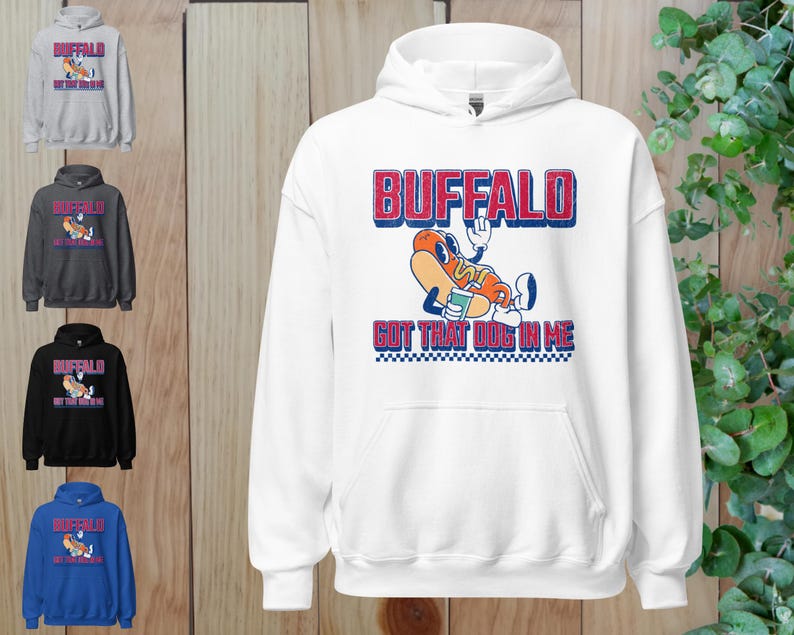 May include: White hooded sweatshirt with a graphic of a cartoon hot dog with the text "BUFFALO GOT THAT DOG IN ME" in red and blue. The sweatshirt is shown in multiple colors, including gray, black, and blue.