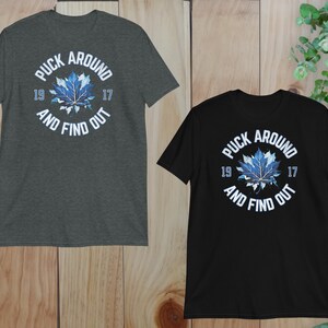 two black and gray shirts on a wooden surface