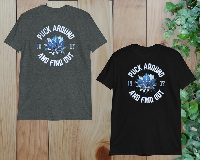 two black and gray shirts on a wooden surface
