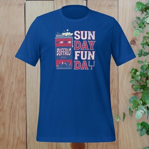 May include: A royal blue t-shirt with a graphic of a can of Buffalo beer and the text "SUN DAY FUN DA Y".