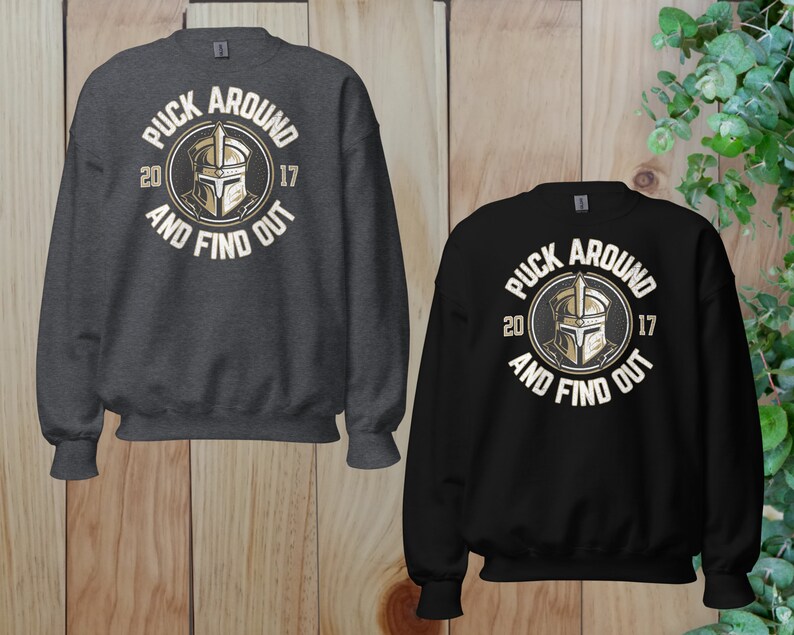 a pair of sweatshirts on a wooden surface
