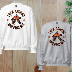 a couple of sweatshirts sitting on top of a wooden floor