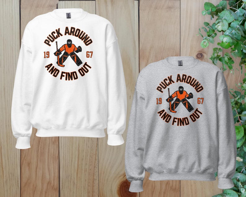 a couple of sweatshirts sitting on top of a wooden floor
