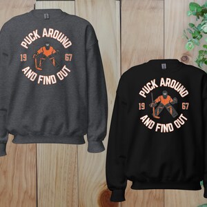 a couple of sweatshirts sitting on top of a wooden floor