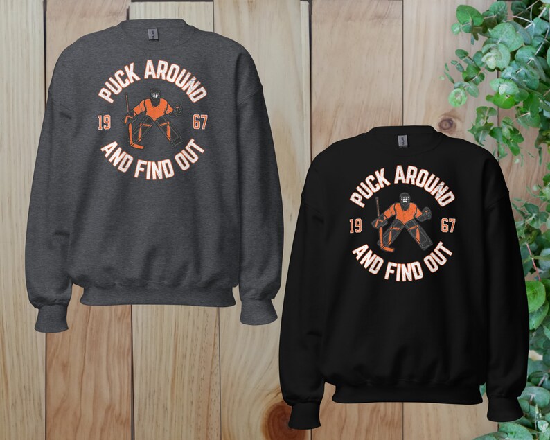 a couple of sweatshirts sitting on top of a wooden floor