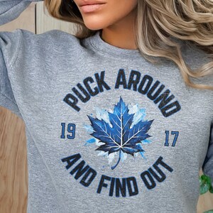 a woman wearing a sweatshirt with a leaf on it