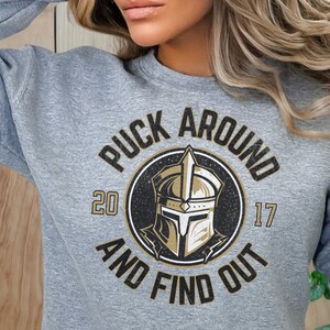 a woman wearing a sweatshirt that says puck around and find out