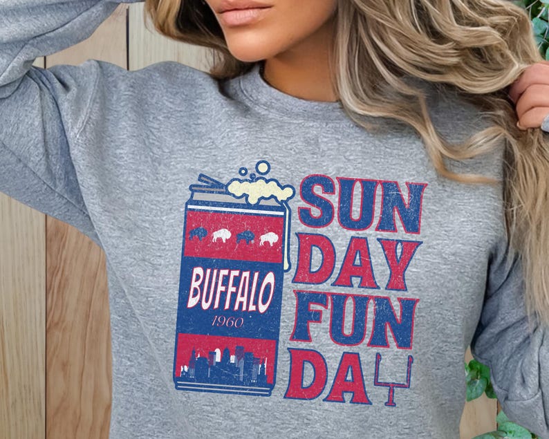 May include: Gray sweatshirt with a vintage-style graphic of a can of beer with the text "Buffalo 1960" and the words "Sun Day Fun Da" in red and blue.