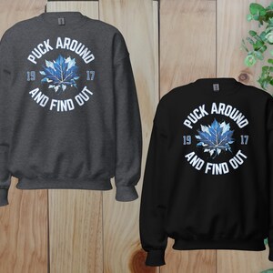 a couple of sweatshirts sitting on top of a wooden floor