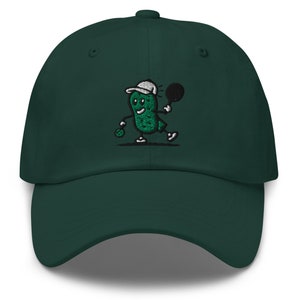May include: A dark green baseball cap with an embroidered cartoon pickle playing tennis. The pickle is wearing a white hat and holding a green tennis racket.