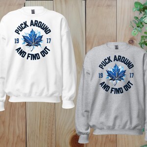 two sweatshirts with the words puck around and find out on them