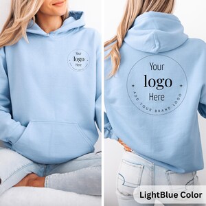 May include: Light blue hoodie with a front pocket and a hood. The front of the hoodie has a circular logo design that says "Your logo Here". The back of the hoodie has the same logo design. The text "LightBlue Color" is at the bottom.