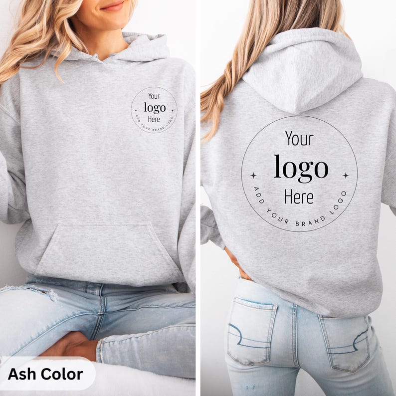 May include: Light gray hoodie with a front pocket and hood. The front and back of the hoodie feature a circular design with the text "Your logo Here" and "Add Your Brand Logo". The bottom left corner of the image has the text "Ash Color".