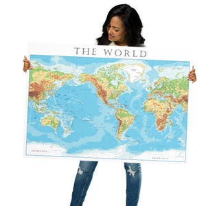 May include: A person holding a large world map with the title "THE WORLD" printed at the top. The map is blue with green and brown landmasses.