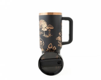 May include: Black travel mug with a copper-coloured lid and handle. The mug has a gold-coloured design of mushrooms on a black background.
