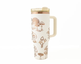 May include: A white stainless steel travel mug with a copper-coloured mushroom design. The mug has a handle and a lid.