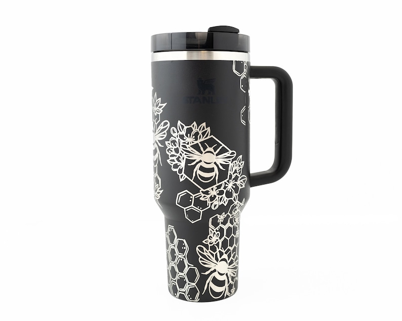 Stanley brand 40 oz tumbler in black with bumble bee and honeycomb design wrapped around the tumbler. Front view.