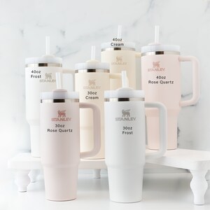 Stanley 40 oz and 30 oz tumblers in additional available colors shown together for size and color comparison. Frost, Cream, and Rose Quartz.