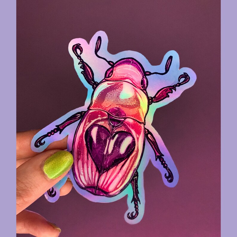 May include: A holographic sticker of a pink and purple beetle with a heart-shaped design on its back.