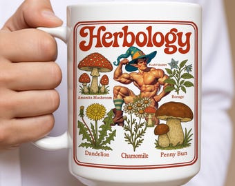 May include: White ceramic mug with a red border featuring the word "Herbology" in a retro font. The mug showcases illustrations of various plants and a muscular elf-like figure. Plant names include Amanita Mushroom, Dandelion, Chamomile, Borage, and Penny Bun.