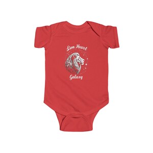 Könnte beinhalten: Ein roter Baby-Body mit einer weißen und grauen Löwen-Grafik. Die Grafik enthält den Text "Lion Heart Galaxy" in einem kreisförmigen Design. Der Body ist aus einem weichen Material gefertigt.