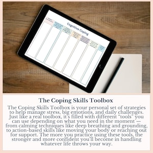 May include: A black tablet displaying a "Cognitive Coping" worksheet, resting on a wooden surface. A pen and paper are next to the tablet. The text below the tablet reads "The Coping Skills Toolbox".