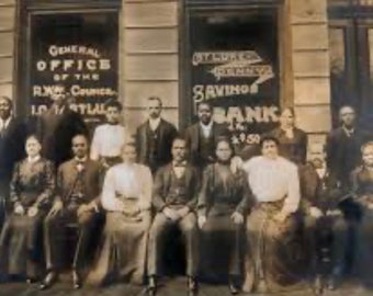 May include: A sepia-toned historical photograph of a group of people posed in front of a building with windows labeled General Office of the R.W. Council and St. Luke's Penny Savings Bank. The individuals wear formal attire from the early 20th century.