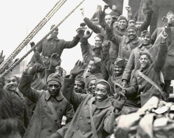 May include: Black and white photo of a group of African American soldiers waving from a ship. They are wearing military uniforms and hats. The soldiers are smiling and appear to be happy.