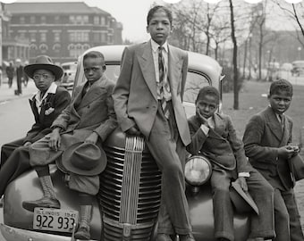 Puede incluir: Una fotografía en blanco y negro de cinco jóvenes con trajes formales y sombreros, posando sobre y alrededor de un coche de 1941 con una matrícula de Illinois que dice 922 933. El grupo viste chaquetas a medida, pantalones y corbatas.