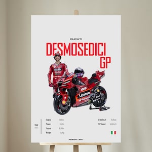Könnte beinhalten: Ein Poster mit einem roten Ducati Desmosedici GP Motorrad und Fahrer. Das Poster zeigt technische Daten: 1000cc Motor, 260Cv Leistung und ein Gewicht von 157kg. Höchstgeschwindigkeit 365km/h. Jahr 2023. Maße in metrischen Einheiten.