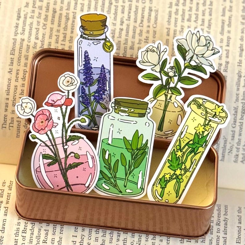 May include: A collection of decorative stickers featuring botanical illustrations. The stickers depict flowers and herbs in glass jars and vials, with a vintage aesthetic. The color palette includes pink, green, yellow, and purple.
